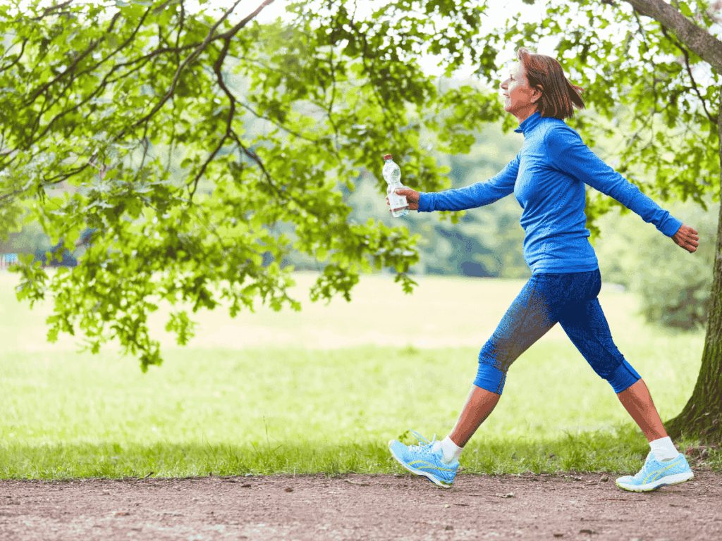 woman walking briskly on a Spring path with a motivated look on her face.