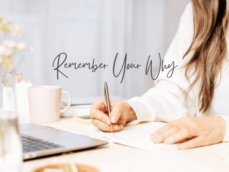an up close photo of a woman's hands while writing near her laptop with a cup of coffee nearby.