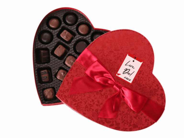 an open heart-shaped red box with red ribbon and gift tag reading "Love, Dad xoxo". Inside the box is a visible assortment of chocolate covered candies.