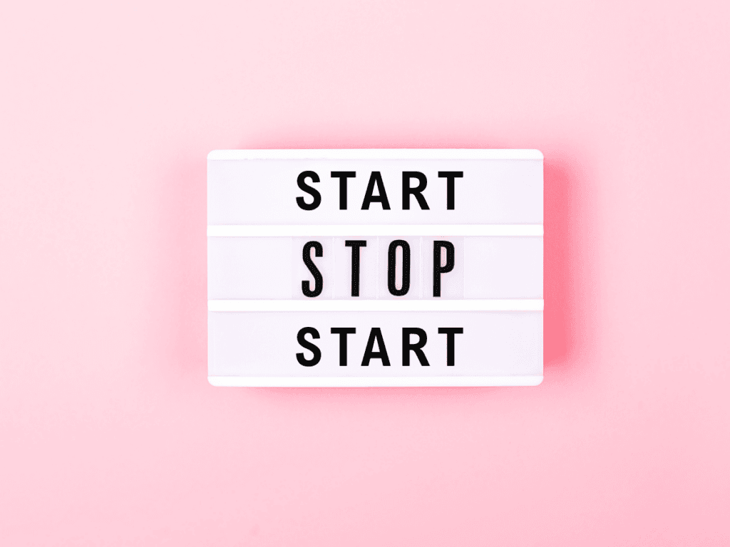 Motivational lightbox sign with "Start, Stop, Start" on pink background.