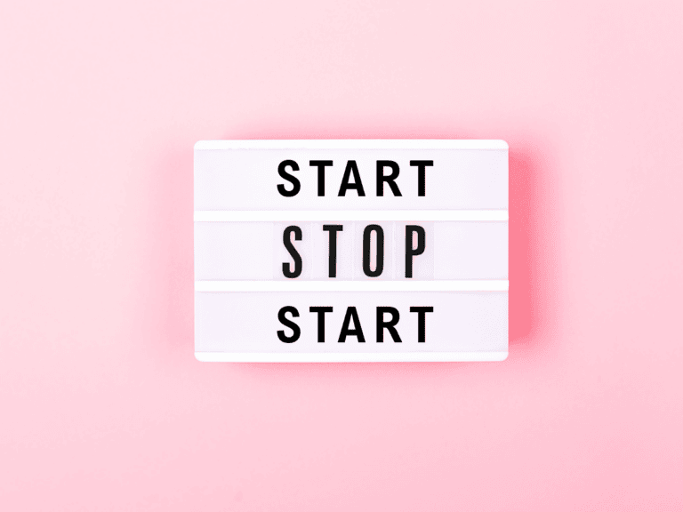 Motivational lightbox sign with "Start, Stop, Start" on pink background.