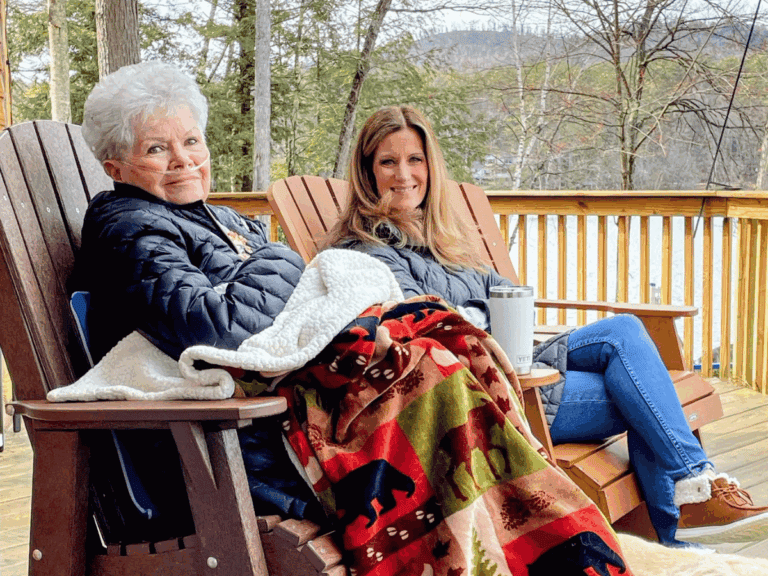 Lynn and her mother sitting together on the deck, with a lakeview behind them, during her mother's last years.