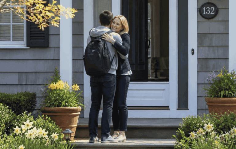 Young woman hugging her son on the porch of their home.